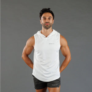 A man wearing a white sleeveless hooded athletic tank top and black shorts, standing against a solid gray studio background.