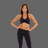 A woman modeling a dark navy athletic set consisting of a halter crop top and matching high-waisted leggings, standing against a solid gray background.