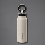 A matte off-white insulated water bottle with a black lid and a black carrying loop, featuring the vertical brand name 'KANATIFIT' printed on the front, set against a solid dark gray background.