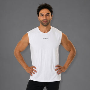A man modeling a white sleeveless athletic tank top with a small black 'KANATIFIT' logo on the chest, set against a solid gray studio background.