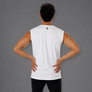 A man viewed from behind wearing a white sleeveless athletic tank top with a small black geometric logo on the upper back, paired with black pants, against a solid gray studio background.