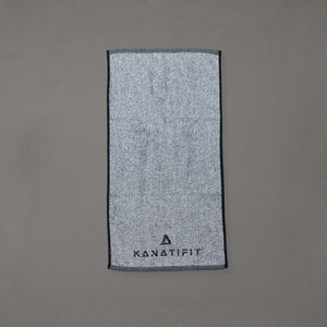 A gray textured towel with a dark gray border and the brand name 'KANATIFIT' printed at the bottom, displayed flat against a solid gray background.